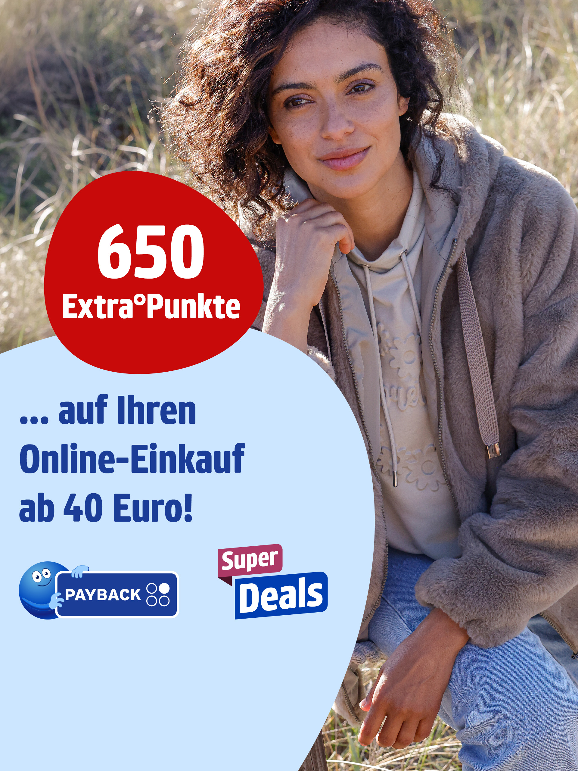 Das Bild zeigt eine Frau in einer braunen Jacke und Jeans, die draußen im Gras bei natürlichem Licht sitzt. Links steht der Text '650 Extra°Punkte ... auf Ihren Online-Einkauf ab 40 Euro!' auf rotem und hellbblauem Hintergrund, darunter das PAYBACK Logo und ein 'Super Deals' Symbol.