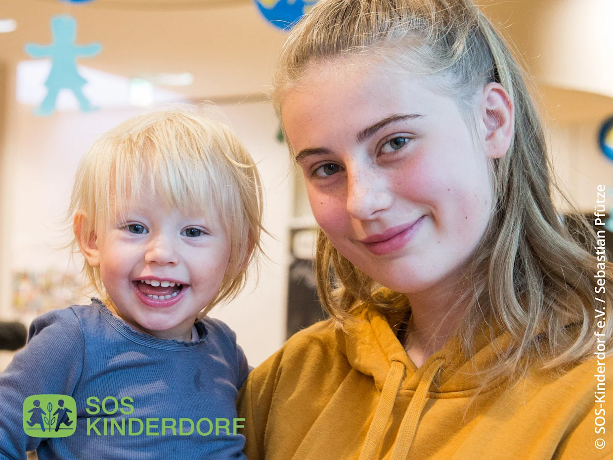 Zwei Model, ein Kleinkind und ein Teenager, stehen nebeneinander. Unten Links das Logo zum Text: 'SOS KINDERDORF'. Auf der rechten Seite der Bild-Quellen-Text: 'SOS-Kinderdorf e.V. / Sebastian Pfütze'. Zwei Model, ein Kleinkind und ein Teenager, stehen nebeneinander. Unten Links das Logo zum Text: 'SOS KINDERDORF'. Auf der rechten Seite der Bild-Quellen-Text: 'SOS-Kinderdorf e.V. / Sebastian Pfütze'.