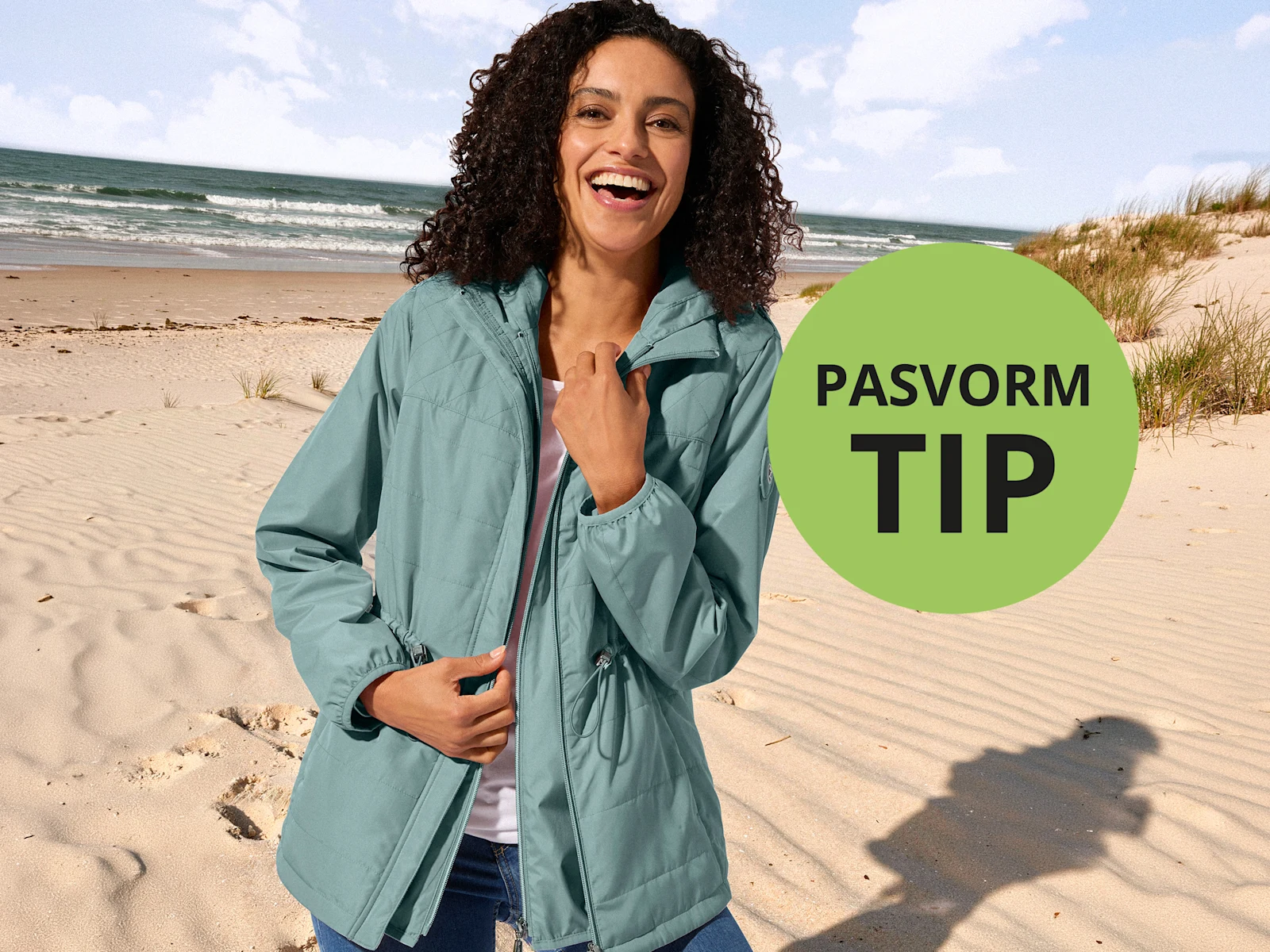 Lachende vrouw in blauwgroene jas op een zonnig zandstrand. Rechts op de voorgrond een groene cirkel met de tekst "PASVORM TIP".