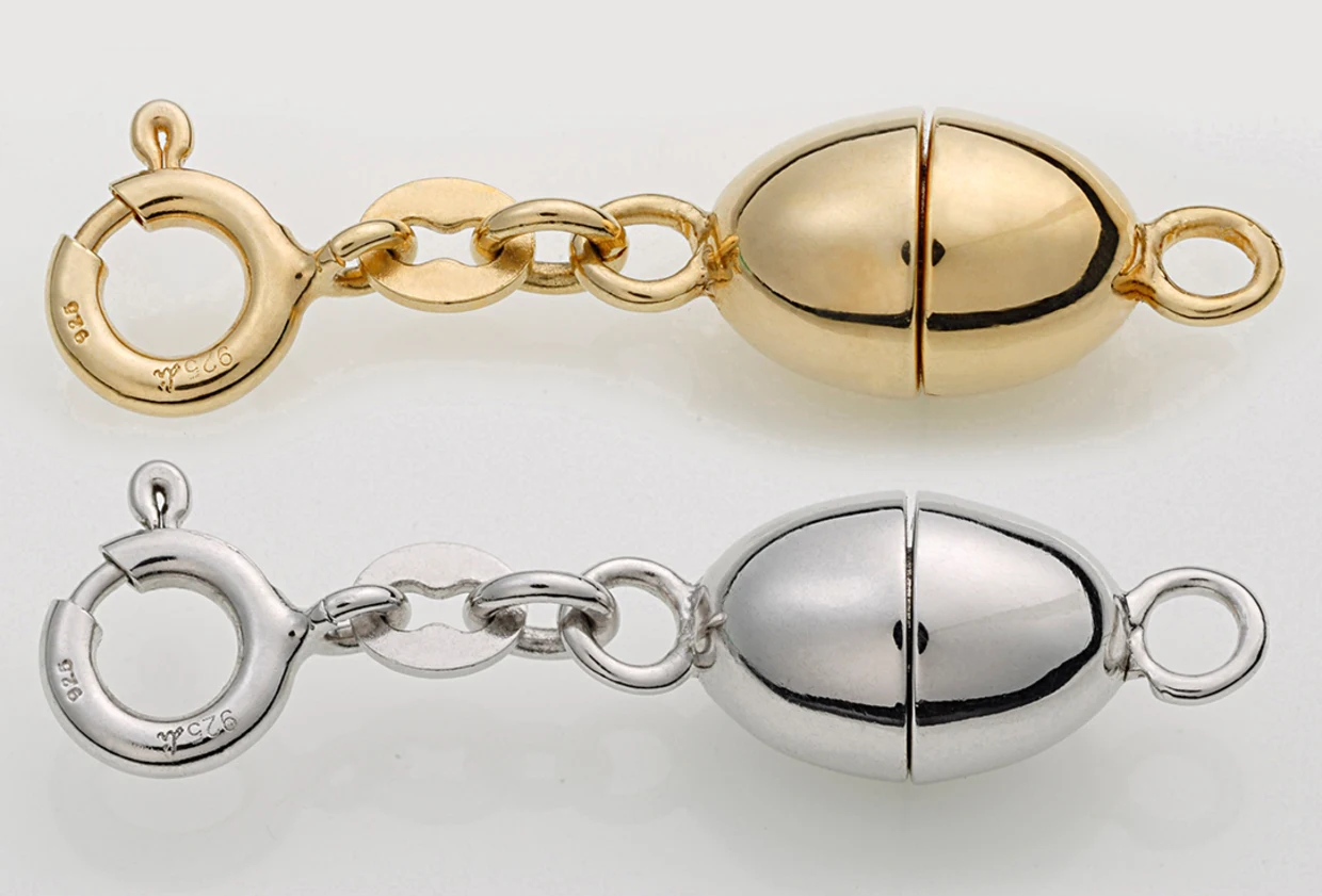 Goldener und silberner Magnetverschluss für Schmuck mit Federringen auf weißem Hintergrund. Goldener und silberner Magnetverschluss für Schmuck mit Federringen auf weißem Hintergrund.