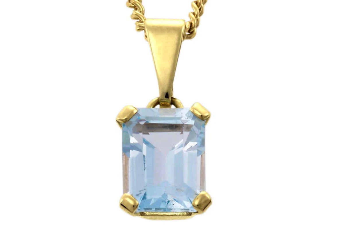 Goldene Halskette mit rechteckigem, hellblauem Edelstein-Anhänger. Goldene Halskette mit rechteckigem, hellblauem Edelstein-Anhänger.