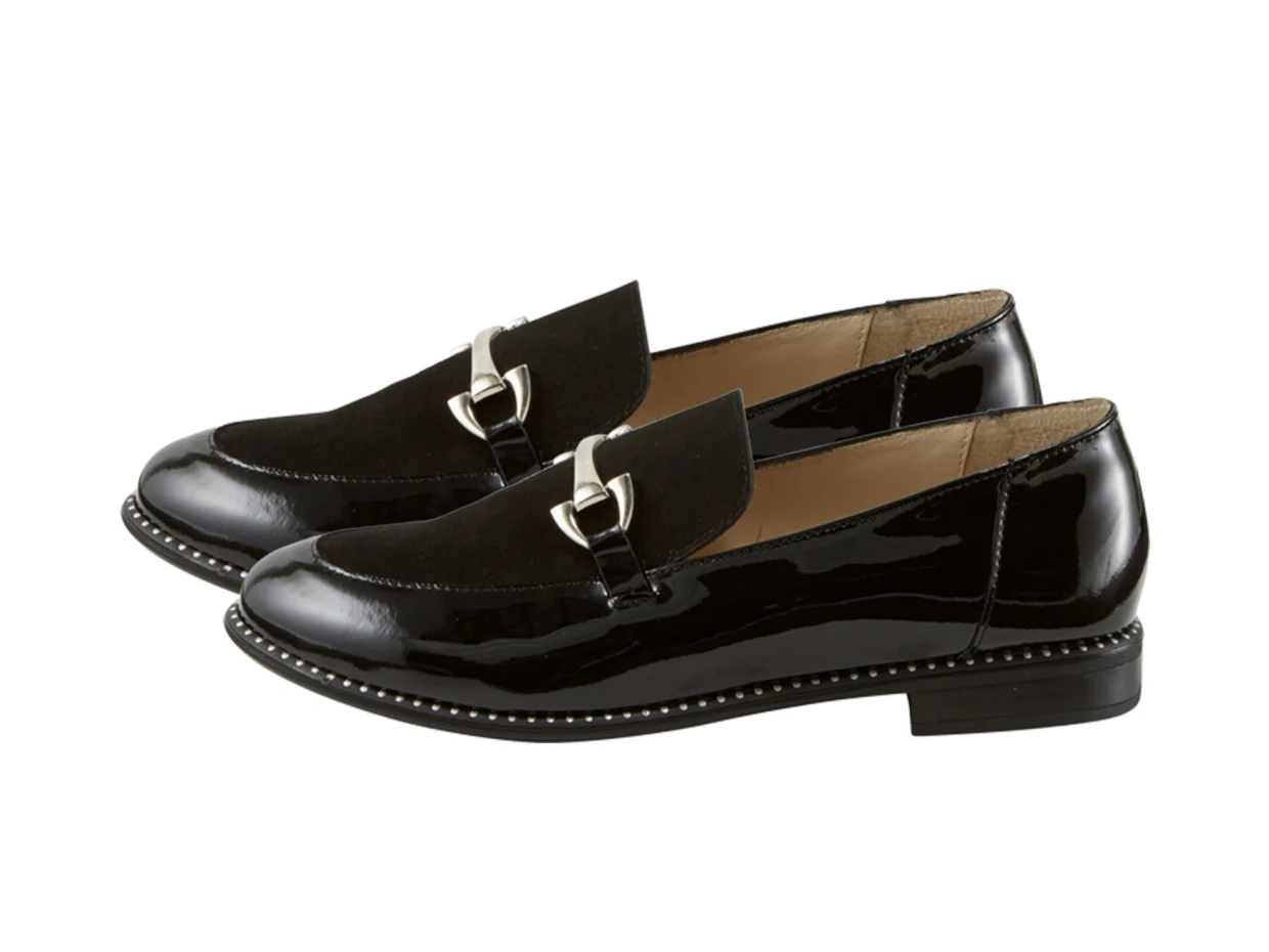 Schwarze Lackleder-Loafer mit silberner Schnalle und flacher Sohle. Schwarze Lackleder-Loafer mit silberner Schnalle und flacher Sohle.