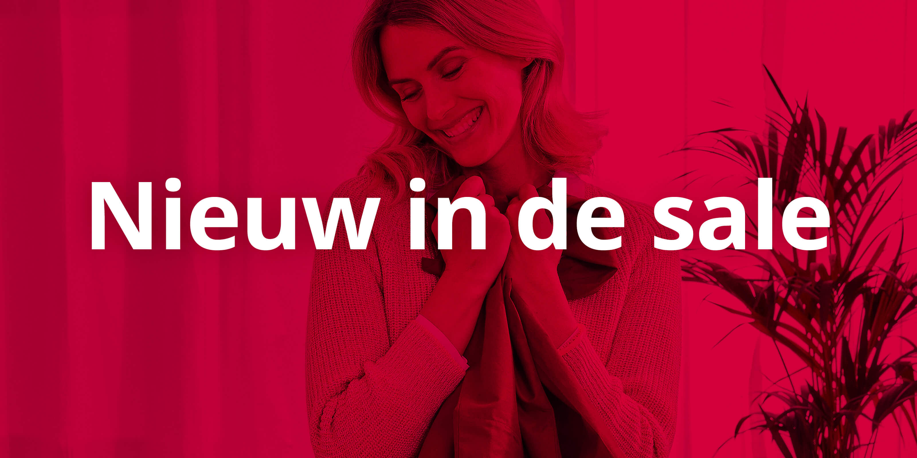 Op de afbeelding is een vrouw te zien die een kledingstuk voor zich houdt, met rechts in beeld een plant. In het midden staat in witte letters de tekst 'Nieuw in de sale', met daaroverheen een krachtig rood filter.