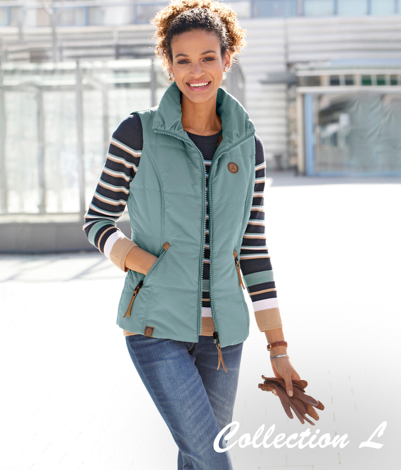 Dame trägt eine mintgrüne Steppweste mit Reißverschluss und einer gestreiften Langarmbluse, kombiniert mit Jeans und braunen Handschuhen in der Hand. Text "Collection L" unten rechts.