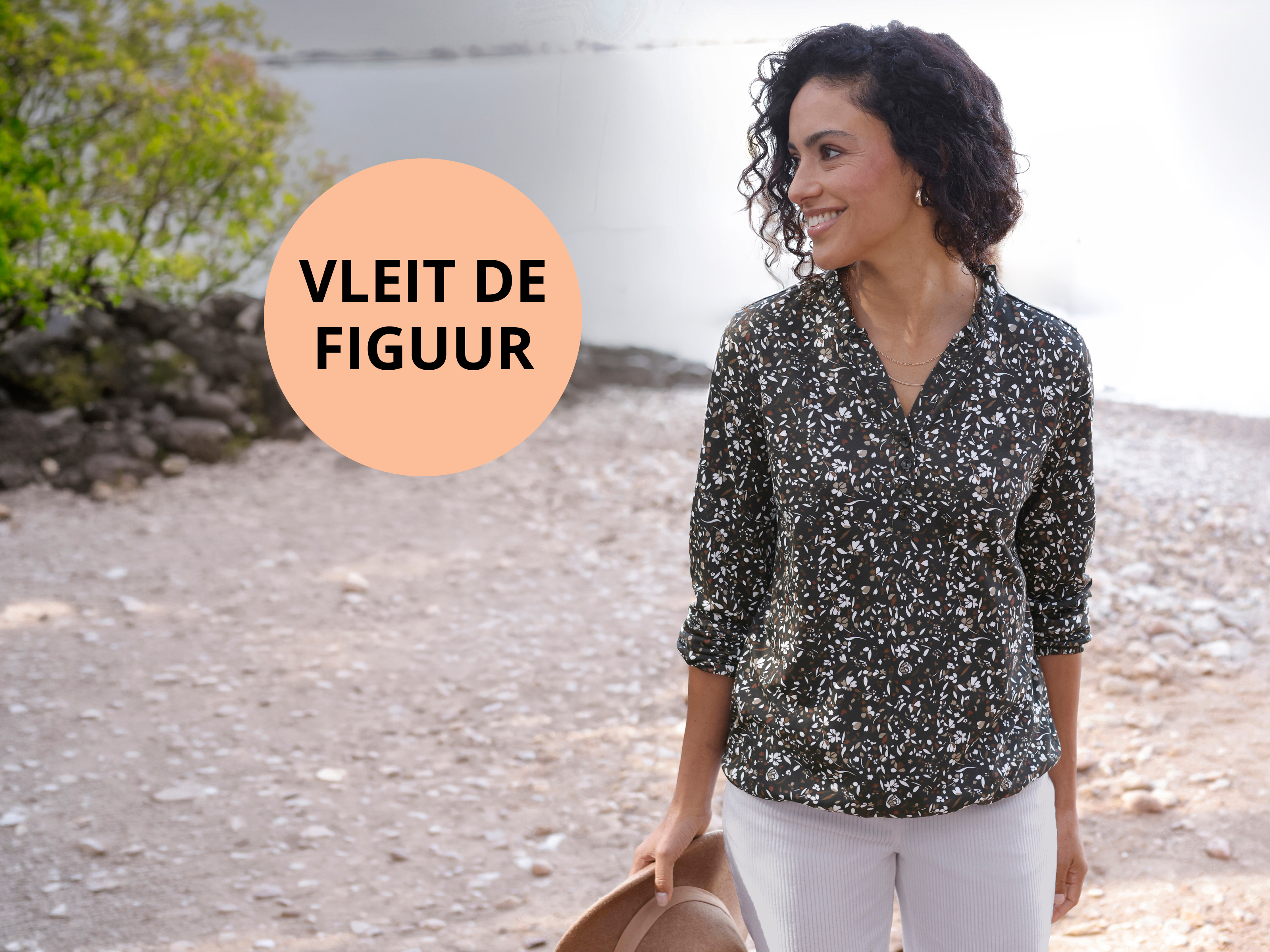 Reclamebanner met een model in een zwart-witte tuniek en een pictogram met de tekst: Flatterend voor het figuur