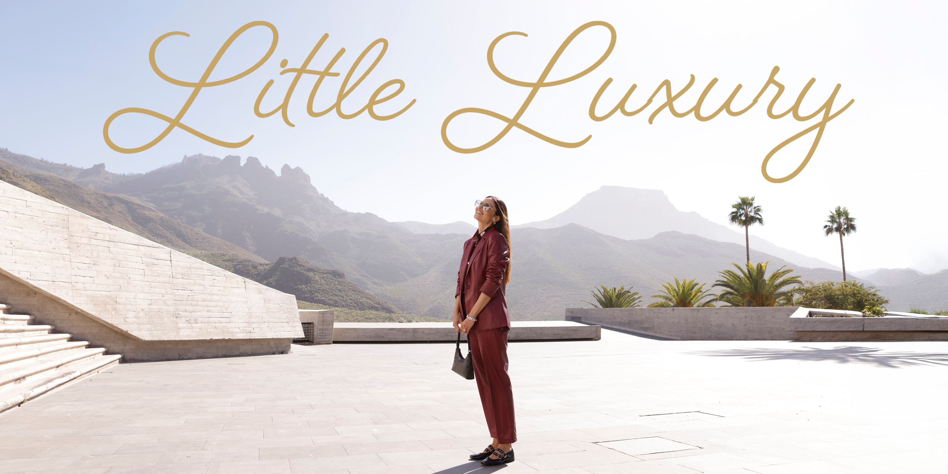 Model in bordeauxfarbenem Lederimitat-Blazer plus -hose und goldenem Schriftzug "Little Luxury"