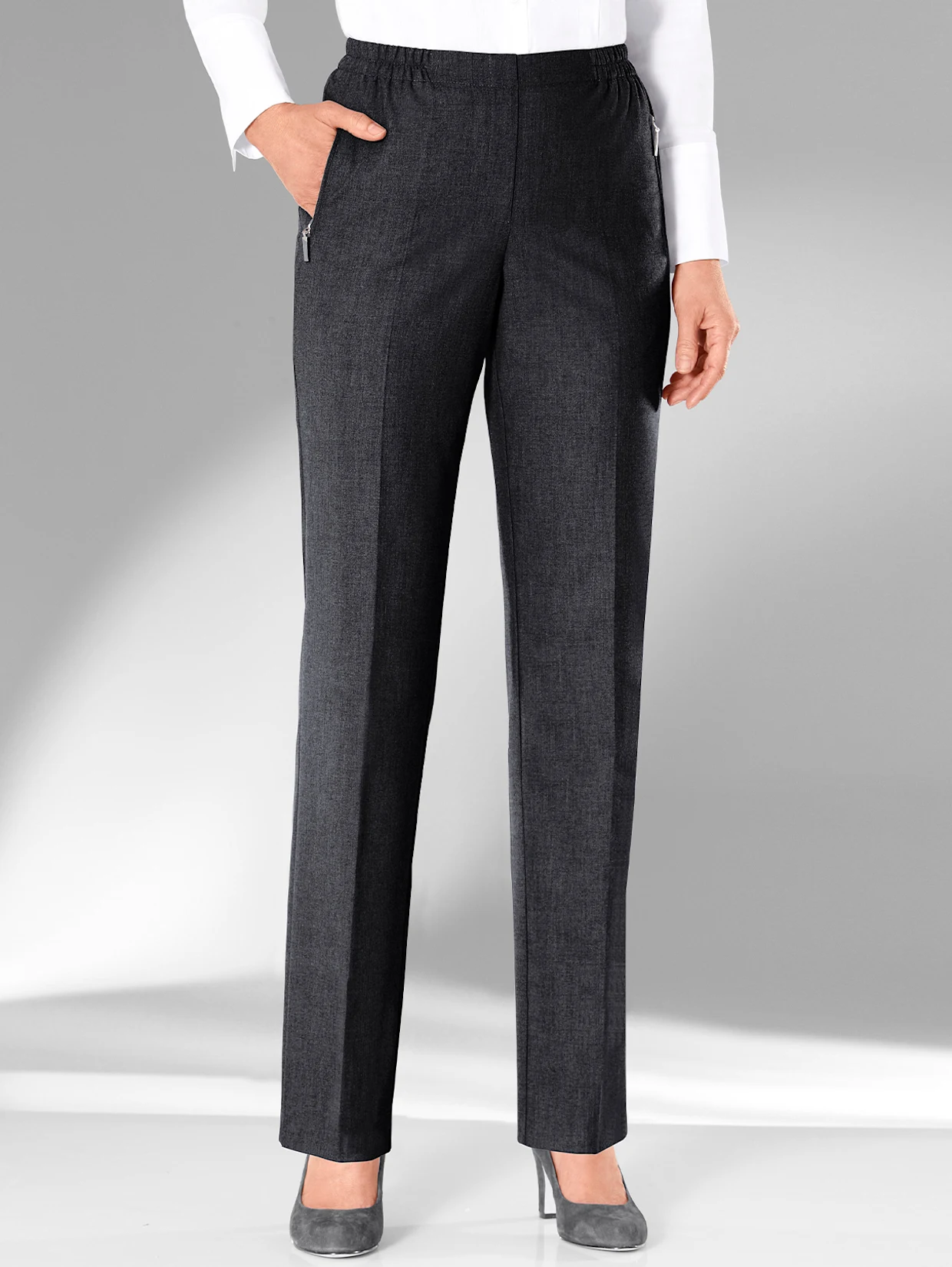 Damenhose in Anthrazit mit elastischem Bund, geradem Schnitt und seitlichen Taschen, kombiniert mit einer weißen Bluse und grauen Pumps. Damenhose in Anthrazit mit elastischem Bund, geradem Schnitt und seitlichen Taschen, kombiniert mit einer weißen Bluse und grauen Pumps.