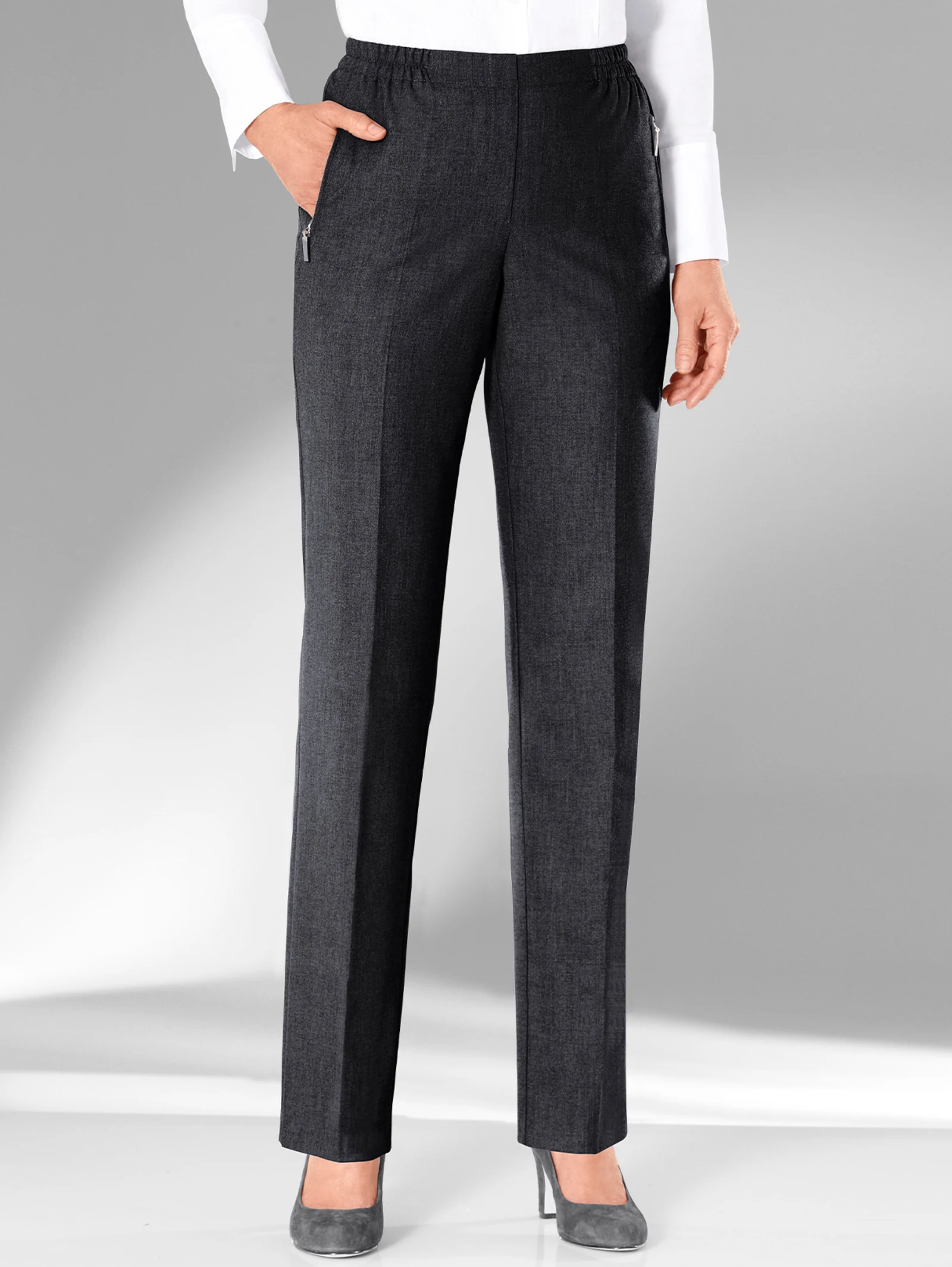 Damenhose in Anthrazit mit elastischem Bund, geradem Schnitt und seitlichen Taschen, kombiniert mit einer weißen Bluse und grauen Pumps. Damenhose in Anthrazit mit elastischem Bund, geradem Schnitt und seitlichen Taschen, kombiniert mit einer weißen Bluse und grauen Pumps.