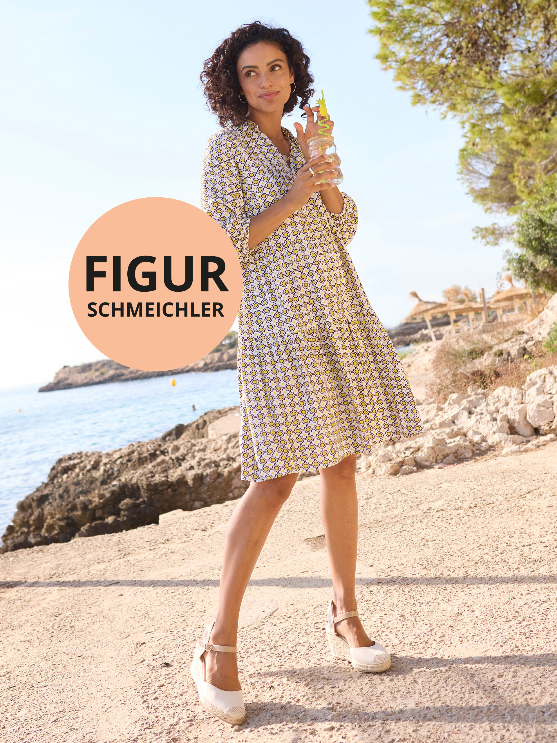 Stehende Frau in gemustertem Kleid am Strand. Text im Kreis: „FIGURSCHMEICHLER“. Sonnig-mediterrane Kulisse.
