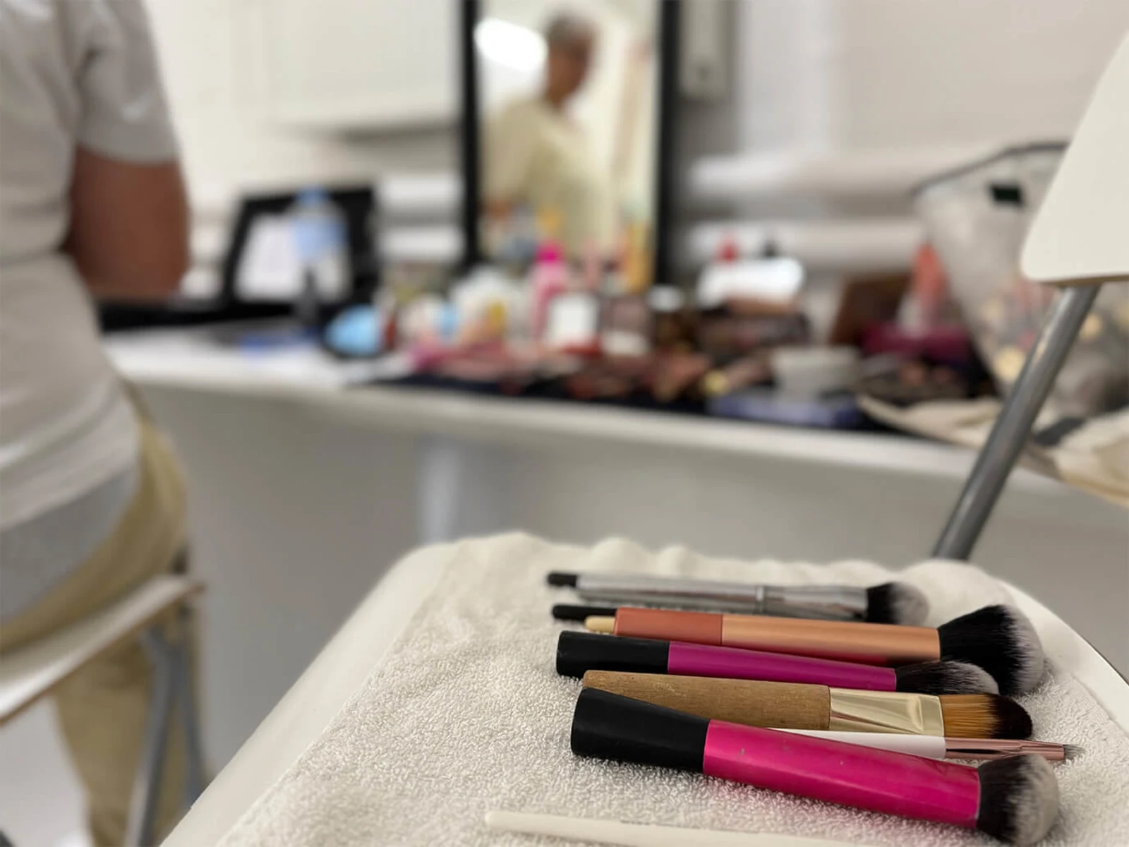 Make-up-Pinsel liegen auf einem Handtuch vor einem Schminktisch. Make-up-Pinsel liegen auf einem Handtuch vor einem Schminktisch.