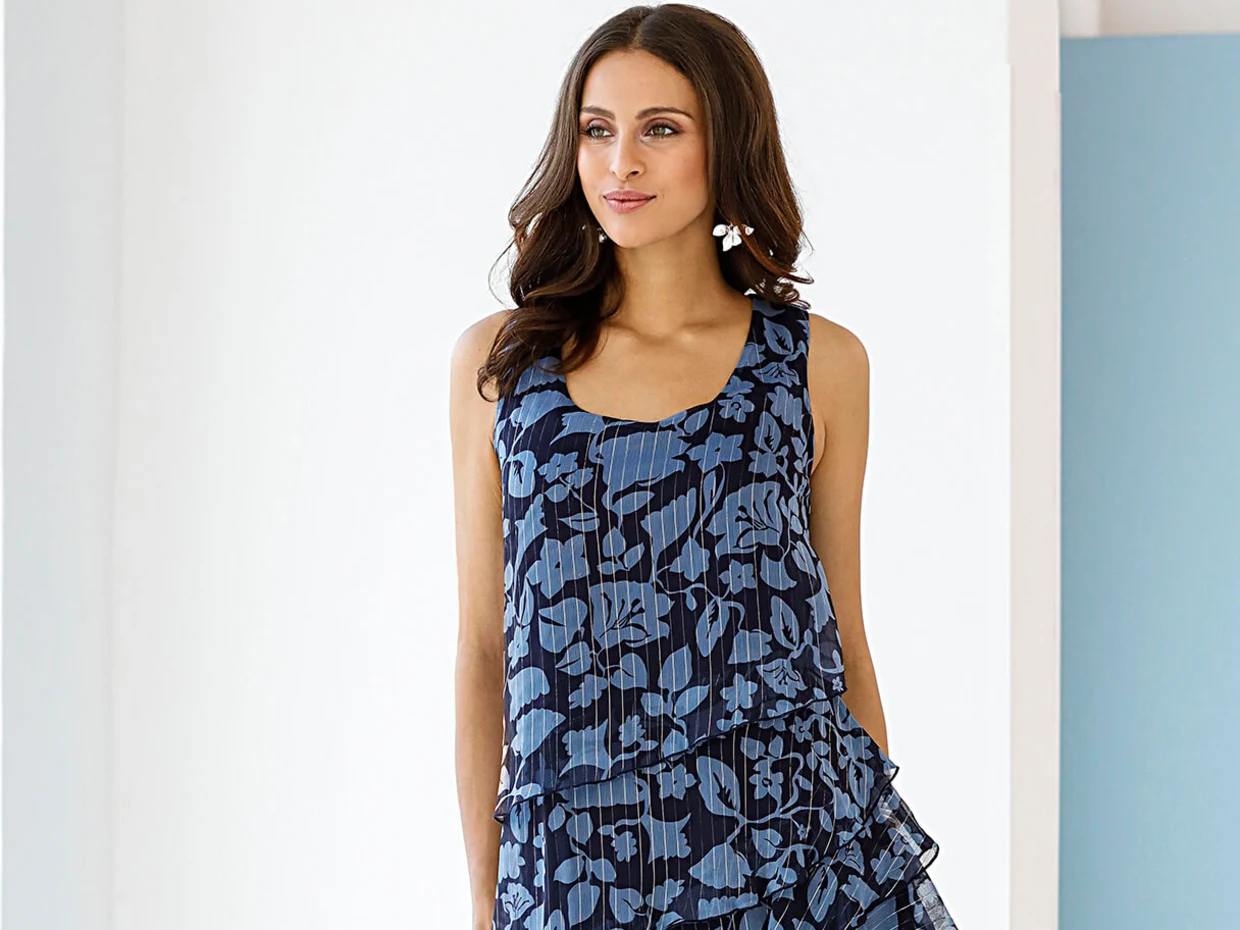 Dunkelblaues ärmelloses Kleid mit floralem Muster und plissierten Details. Dunkelblaues ärmelloses Kleid mit floralem Muster und plissierten Details.