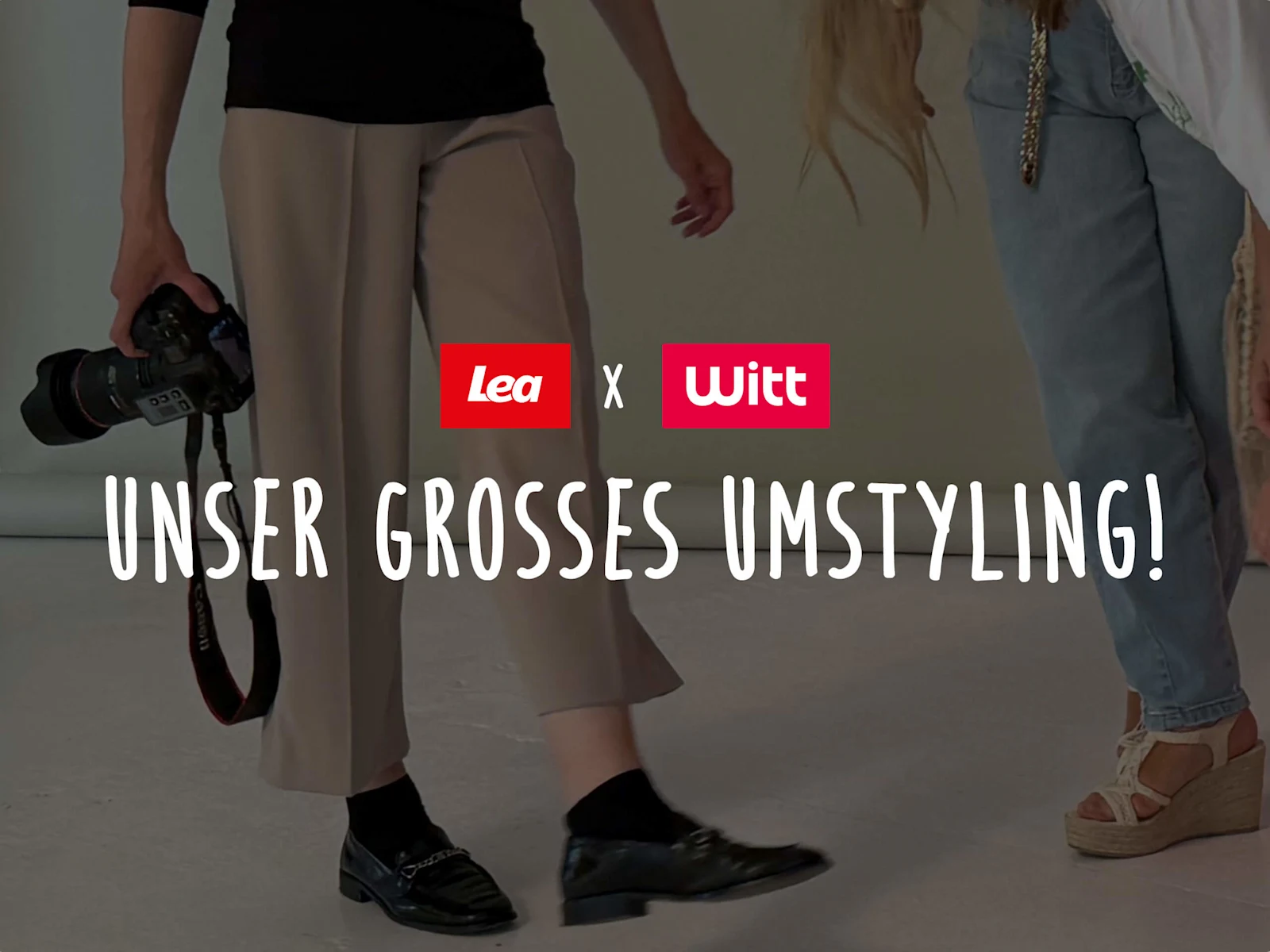 Das Bild zeigt den Text 'Lea x Witt Unser großes Umstyling!'. Der Hintergrund zeigt einen Ausschnitt aus einem Fotoshooting: Links eine Person mit Kamera, rechts eine Person in Jeans, beide stehen auf hellem Boden, der Text ist mittig darübergelegt.