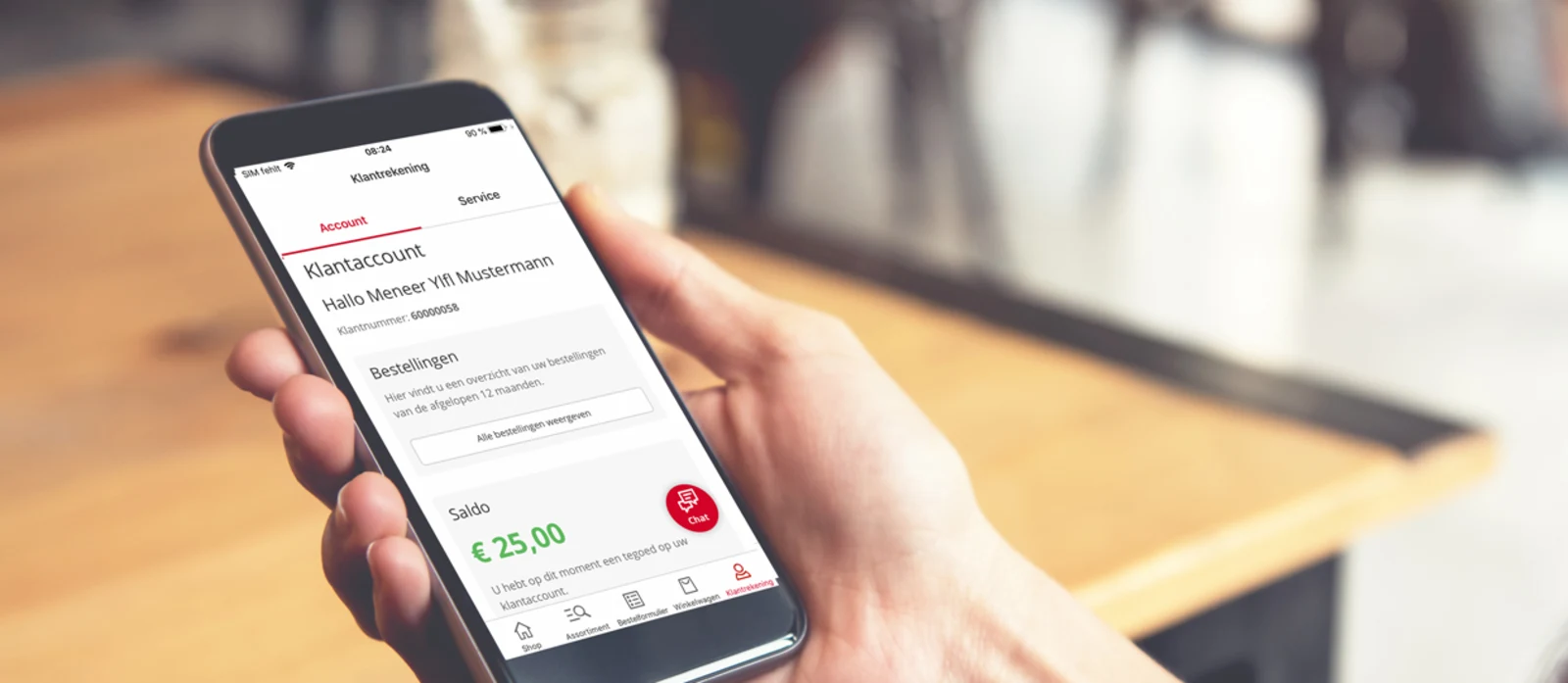 Hand houdt een smartphone vast met een geopend menu op het scherm, op de achtergrond een houten tafel. Hand houdt een smartphone vast met een geopend menu op het scherm, op de achtergrond een houten tafel.