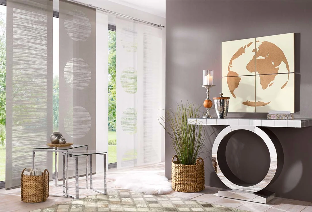 Moderner Wohnraum mit bodenlangen Schiebegardinen, dekorativem Beistelltisch aus Glas und Metall, Wandbild mit Weltkartenmotiv und stilvollen Wohnaccessoires wie Kerzenhalter und Korb mit Pflanze. Moderner Wohnraum mit bodenlangen Schiebegardinen, dekorativem Beistelltisch aus Glas und Metall, Wandbild mit Weltkartenmotiv und stilvollen Wohnaccessoires wie Kerzenhalter und Korb mit Pflanze.