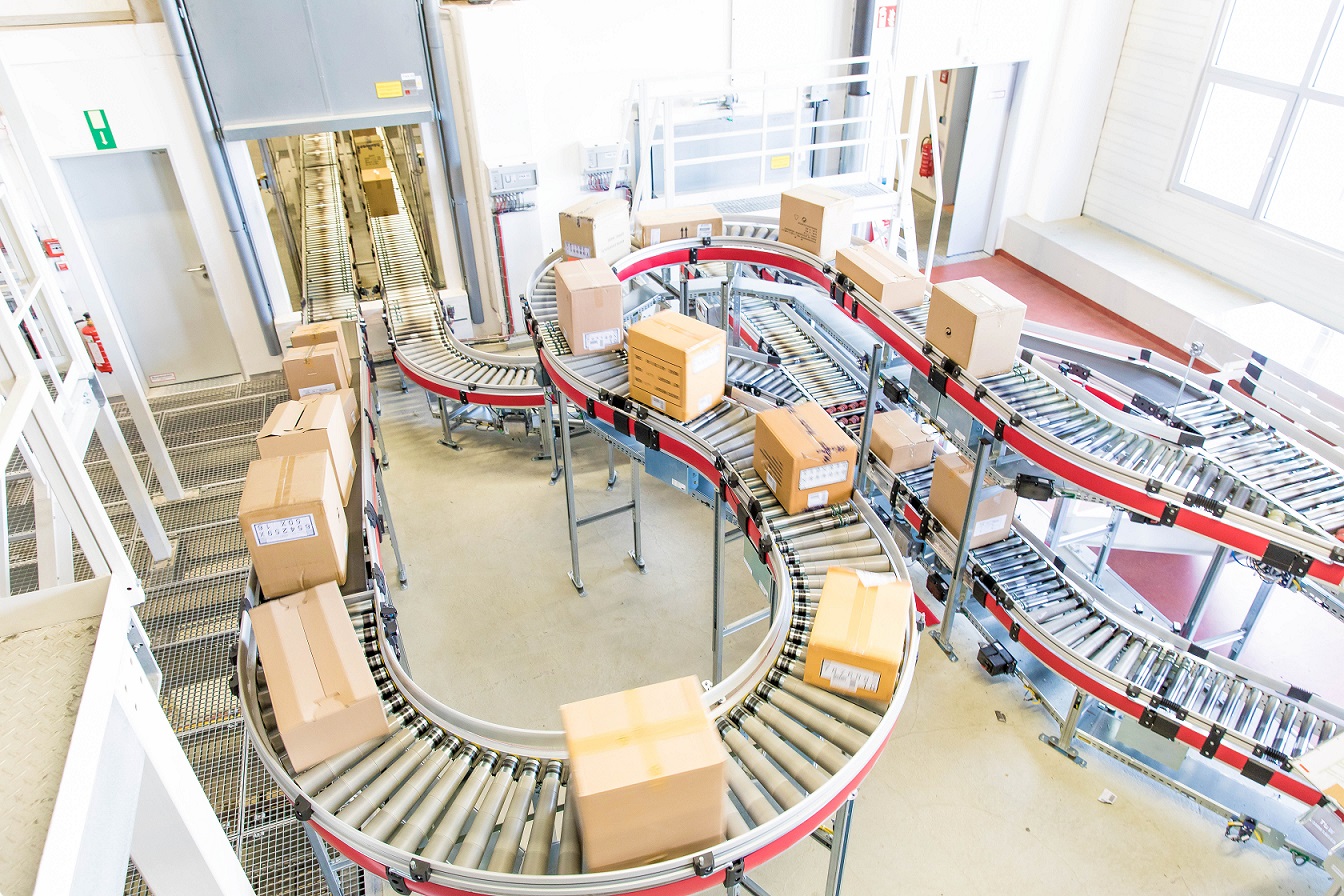 Förderband mit Kartons in einer modernen Lagerhalle.