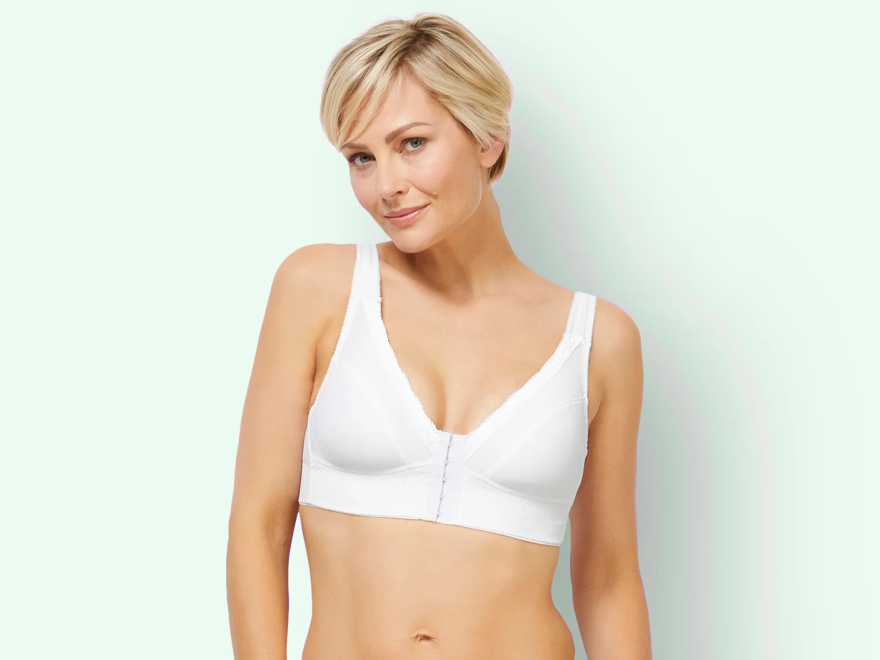 Weißer bügelloser BH mit V-Ausschnitt und breiten Trägern vor mintgrünem Hintergrund.