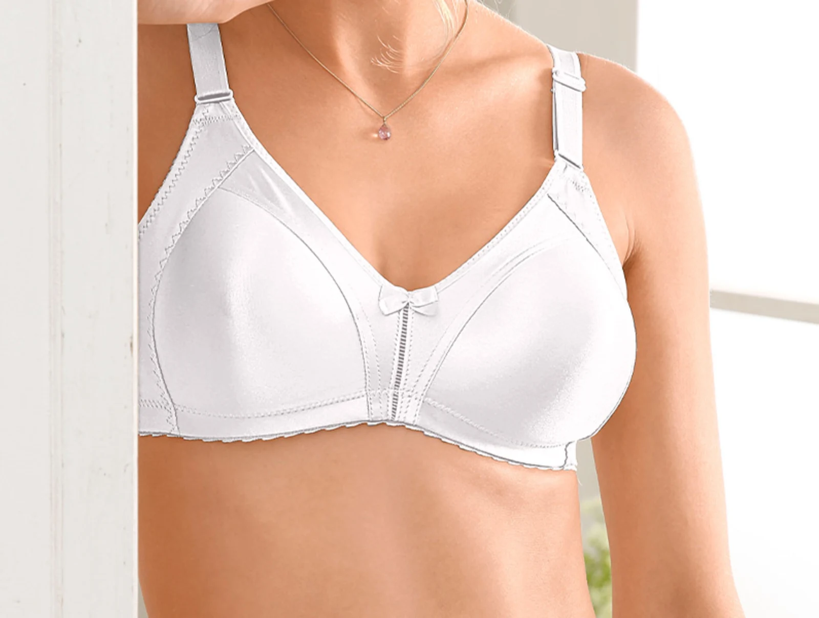 Witte soft-bh zonder beugel met decoratieve strik en verstelbare schouderbandjes.