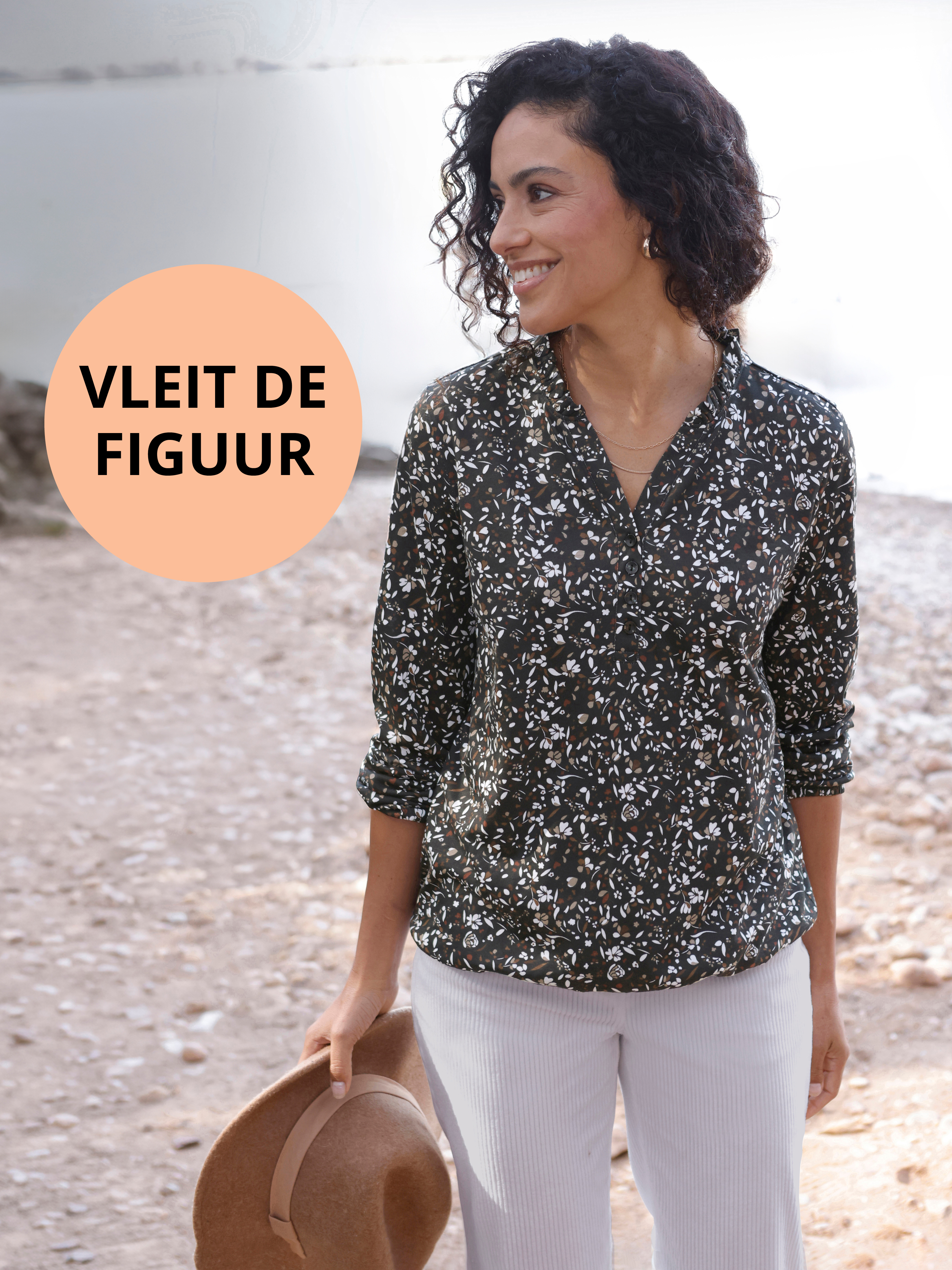 Reclamebanner met een model in een zwart-witte tuniek en een pictogram met de tekst: Flatterend voor het figuur