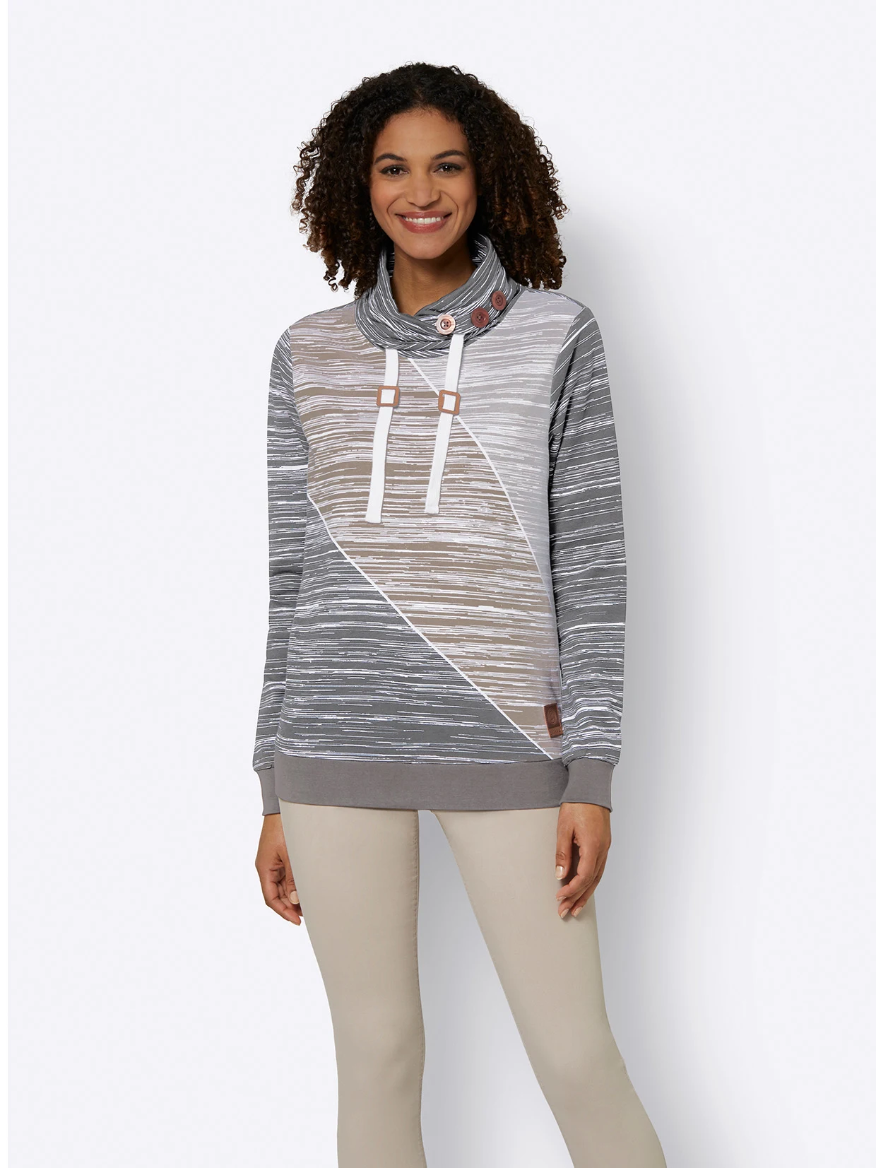 Langärmliger Damen-Pullover mit grauem und beigem Streifenmuster, asymmetrischem Design, Stehkragen mit Knöpfen und dekorativen Kordeln, kombiniert mit beigefarbener Hose.