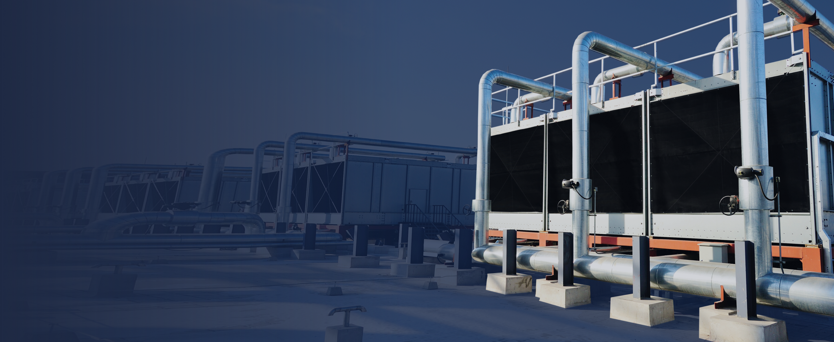 Industrial cooling system on a rooftop with large metal pipes and heat exchangers, highlighting modern HVAC technology for energy-efficient climate control solutions.