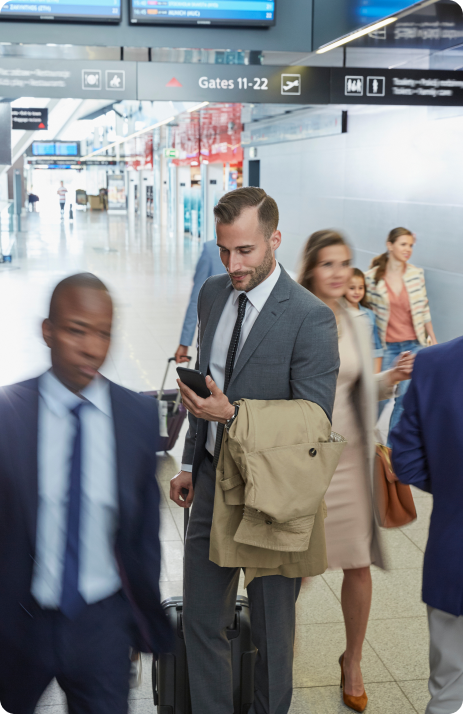 A person standing in midway and looking at phone and smiling