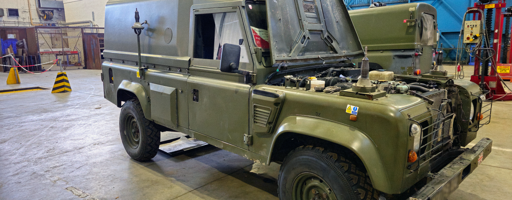 Mechanical engineers working on an Army Land Rover in a workshop