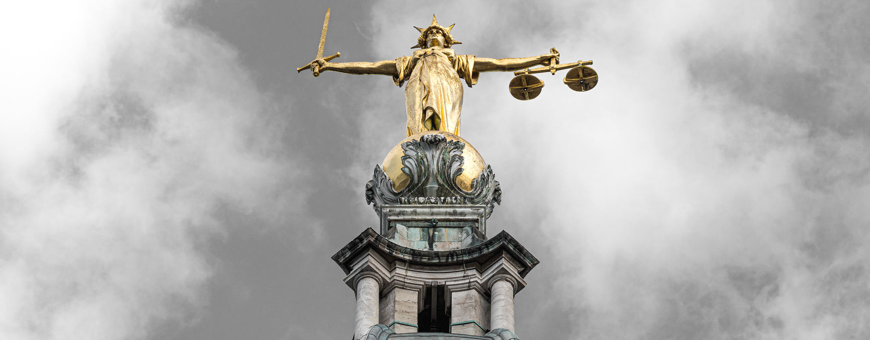 Lady Justice statue atop the Old Bailey in London, holding scales and a sword