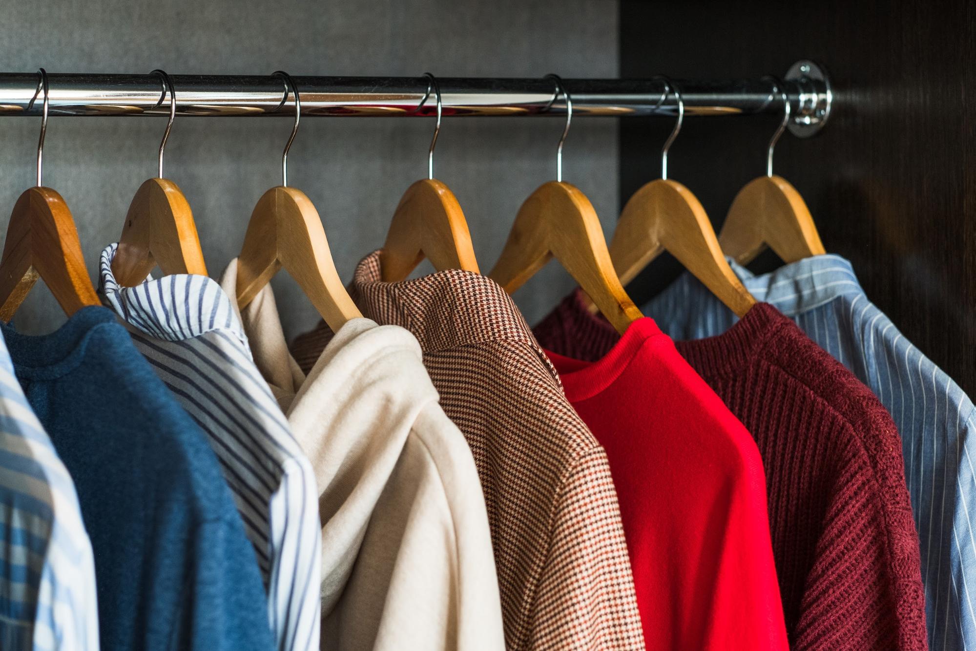 shirts hanging in a closet on wood hanger 