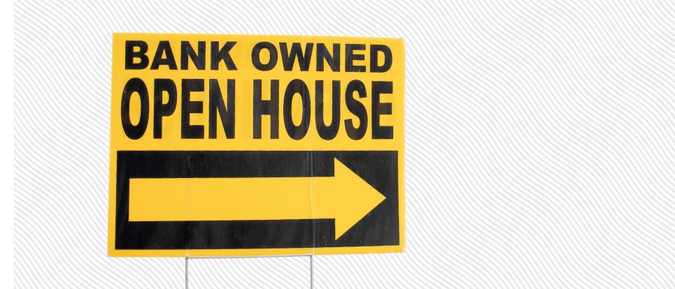 Yellow sign with black lettering that reads "Bank Owned Open House" with an arrow pointing right.