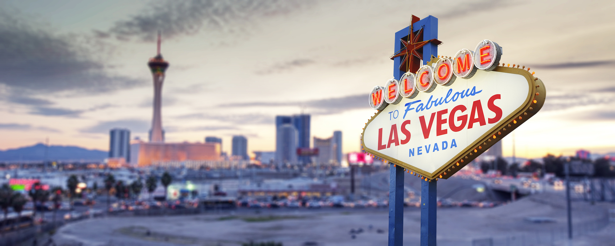 View of downtown Vegas in front of the "Welcome to Fabulous Las Vegas" sign. 