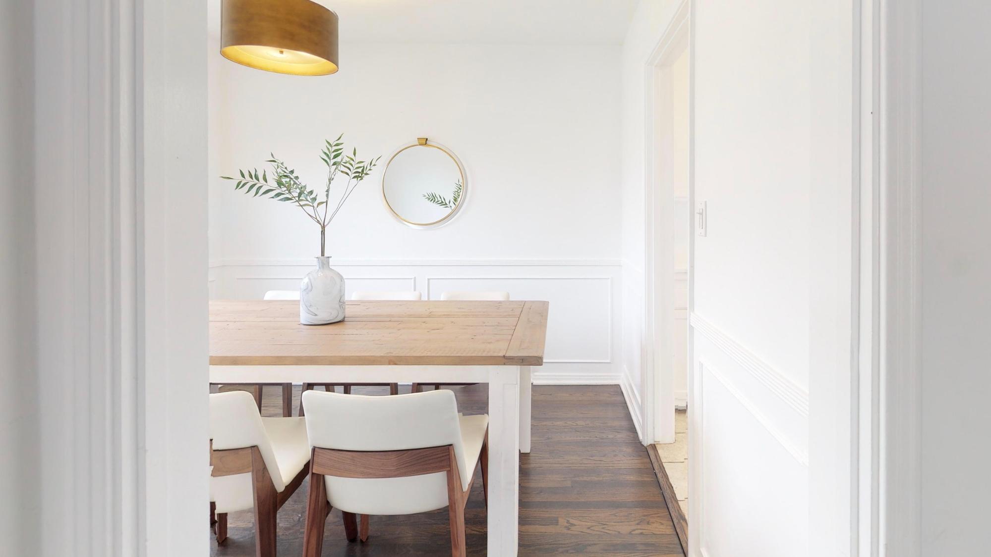 light wood dining table surrounded by white walls