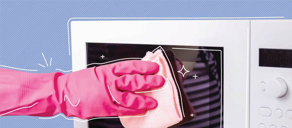 pink rubber glove wiping down white microwave on blue background 