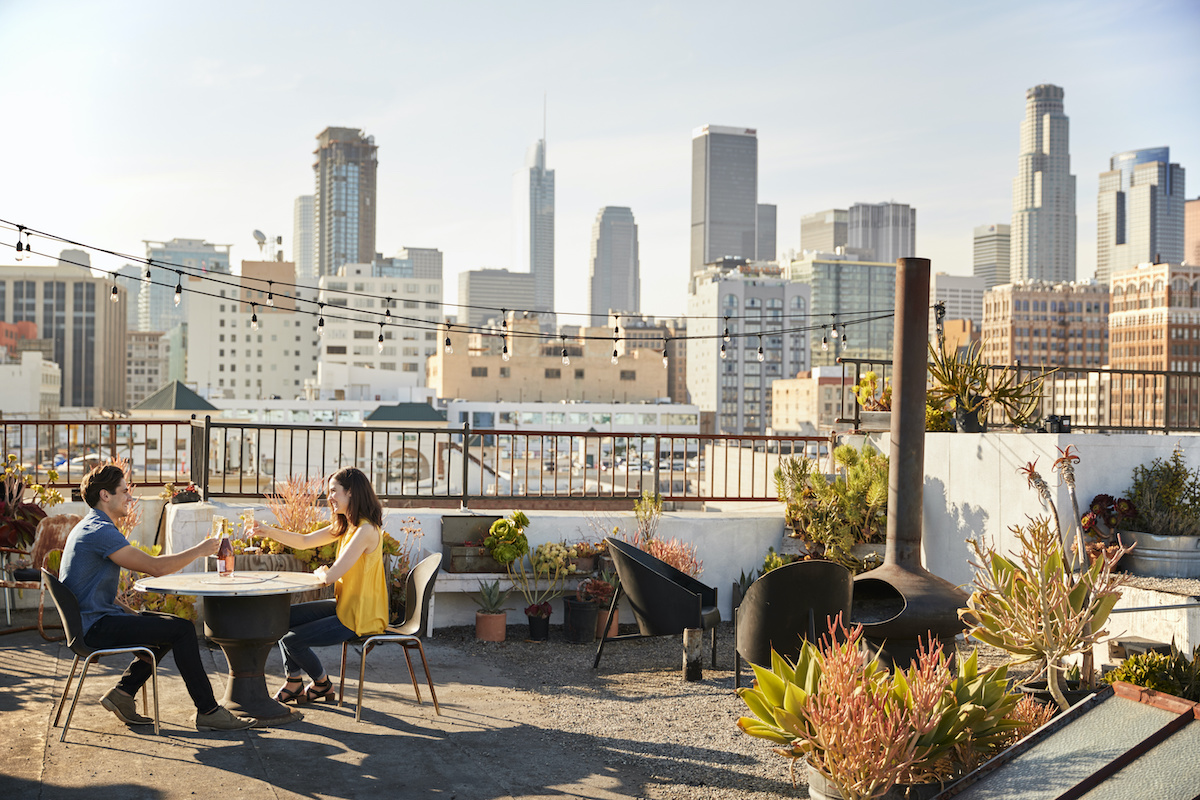 2 friends sitting on an apartment rooftop