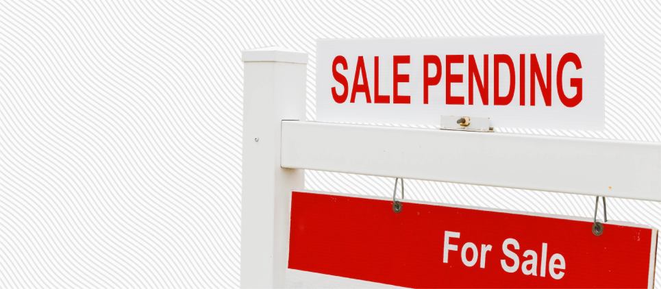 A sale pending sign sits atop a for sale sign.
