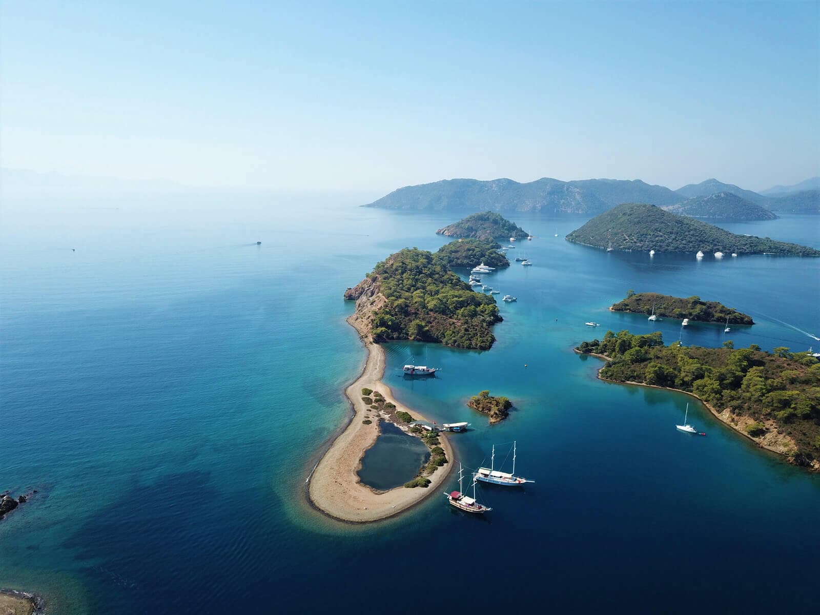 Göcek'in 12 Adalar bölgesinde, turkuaz sularda seyreden bir günlük tur teknesi.
