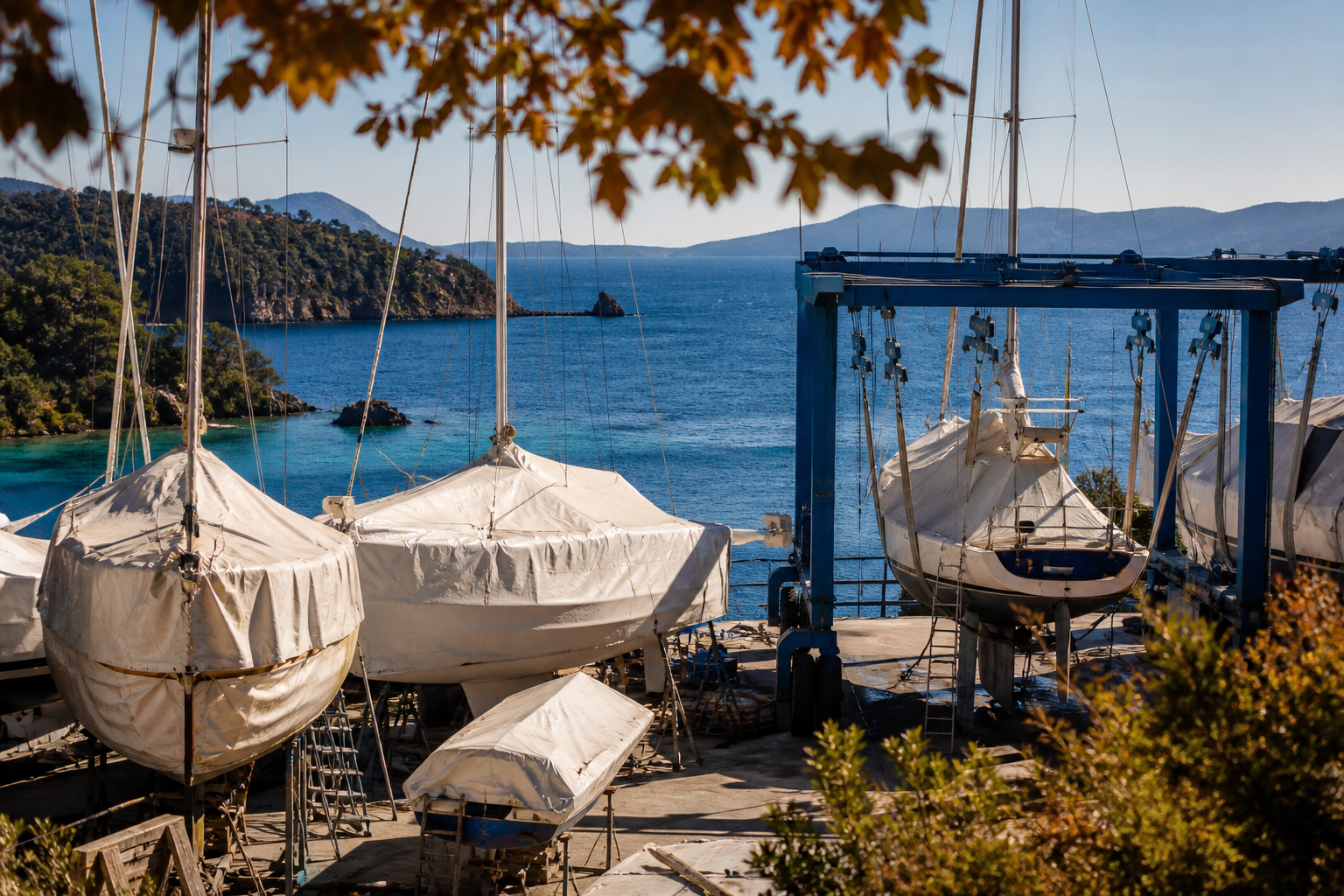 A travel lift and covered boats in the boatyard