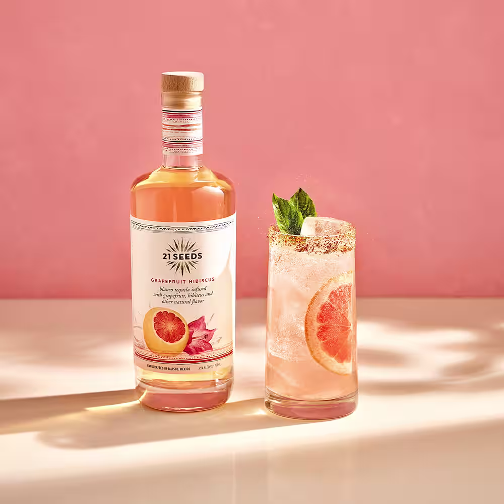 A paloma cocktail made with 21Seeds Grapefruit Hibisucus Infused Tequila, garnished with mint and  a grapefruit slice.