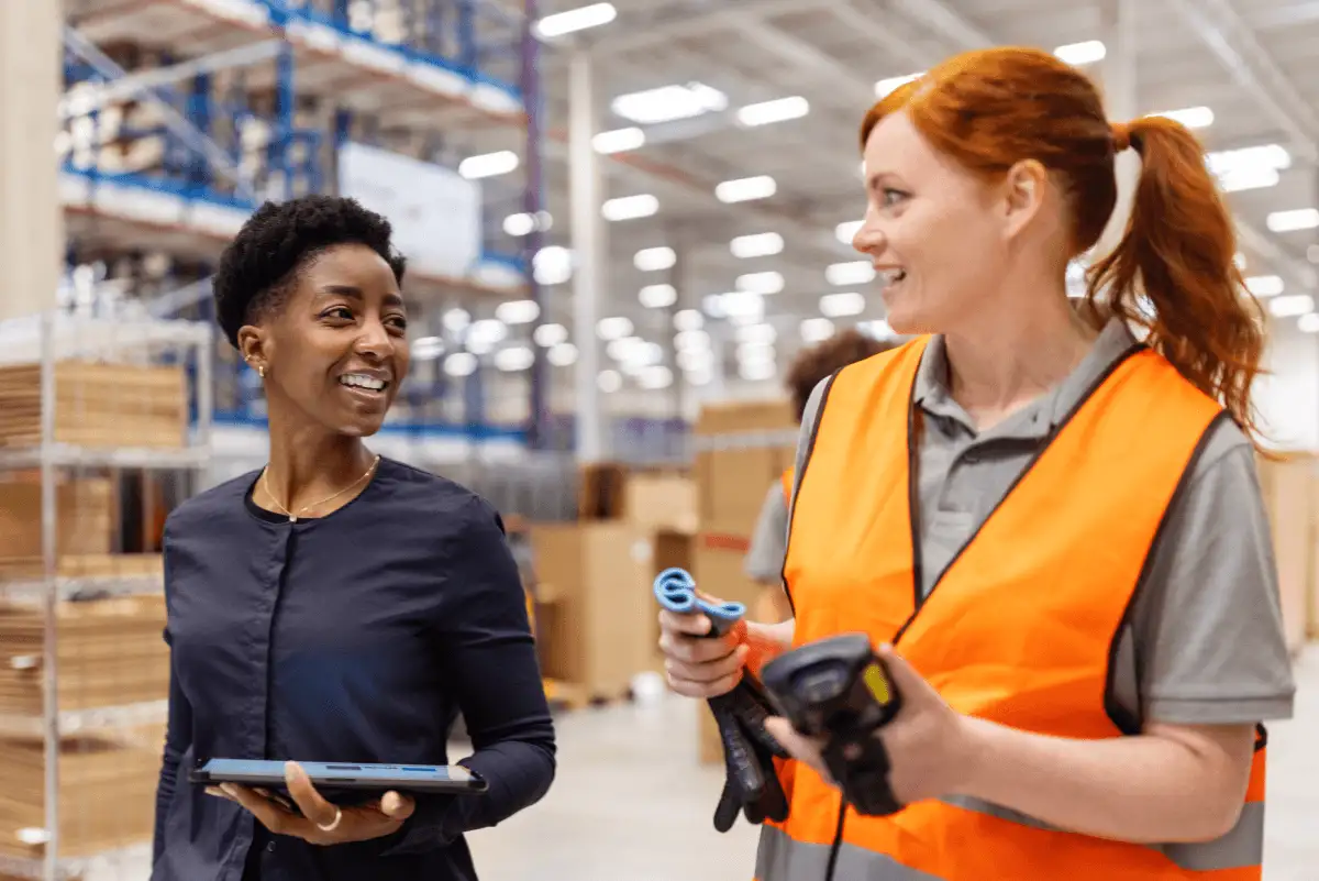 Two employees in a manufacturing warehouse use DocuSign to improve their supply chain