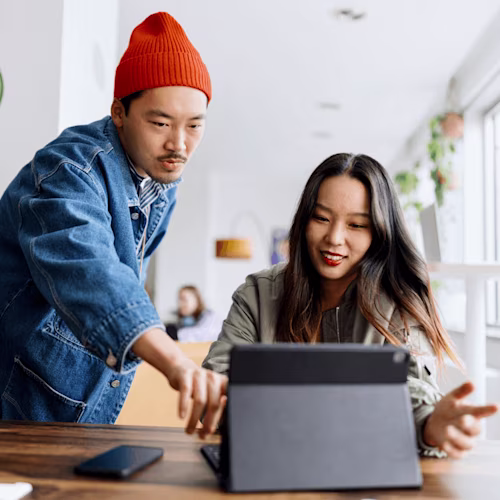 A man in a mustard-colored shirt sits indoors, engaged in a discussion about Docusign. Green plants are visible in the background.