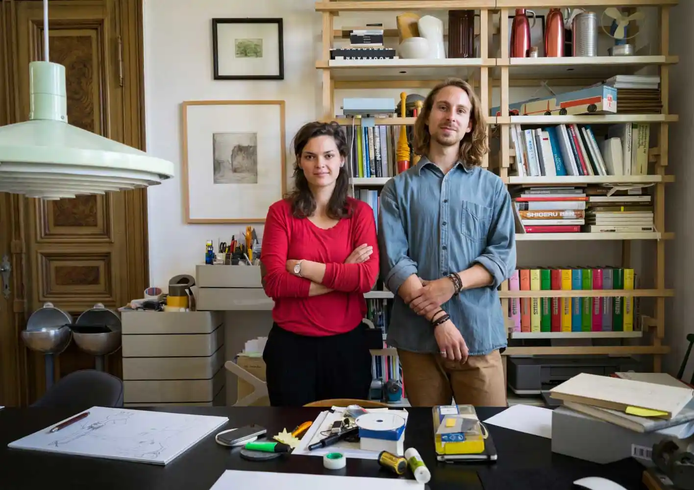 Un homme et une femme d'affaires debout derrière un bureau.