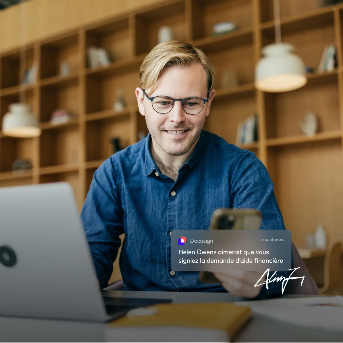 A man looks at his phone with a notification from DocuSign