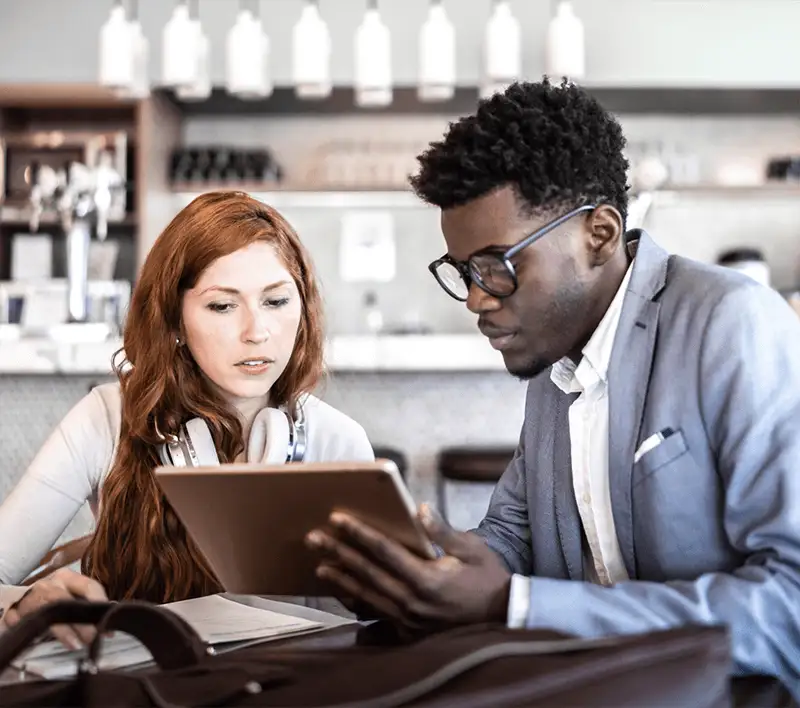 Deux collègues regardant une tablette sur le lieu du travail