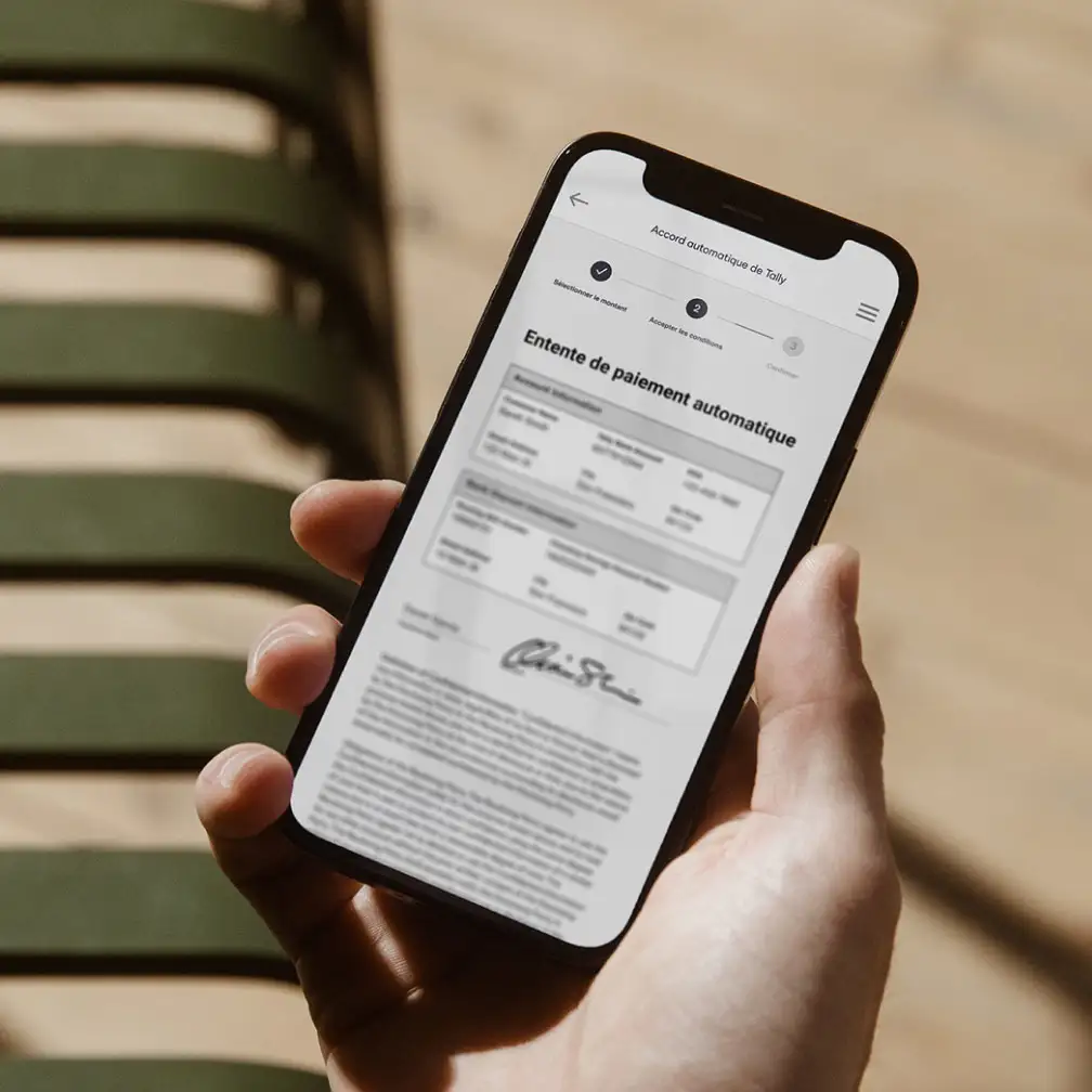 Main tenant un téléphone montrant un contrat avec Tally via Docusign