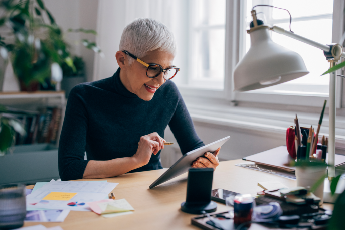 Femme avec une tablette sur un bureau de travail
