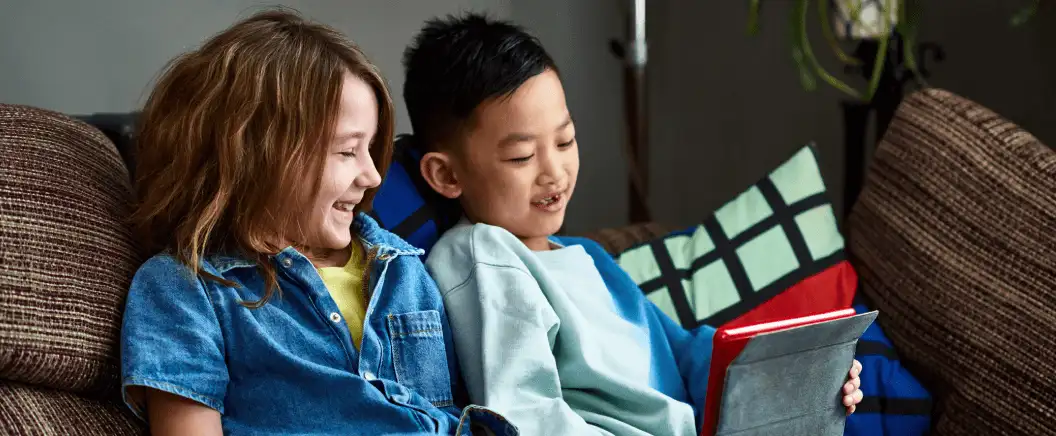 Two children look at a tablet. DocuSign offers solutions for using electronic signatures in K-12 education.