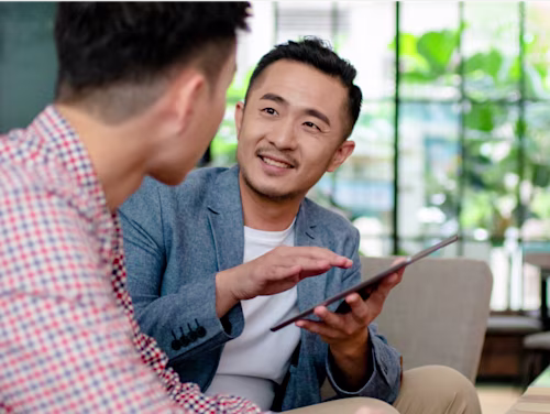 Two men collaborating over a tablet