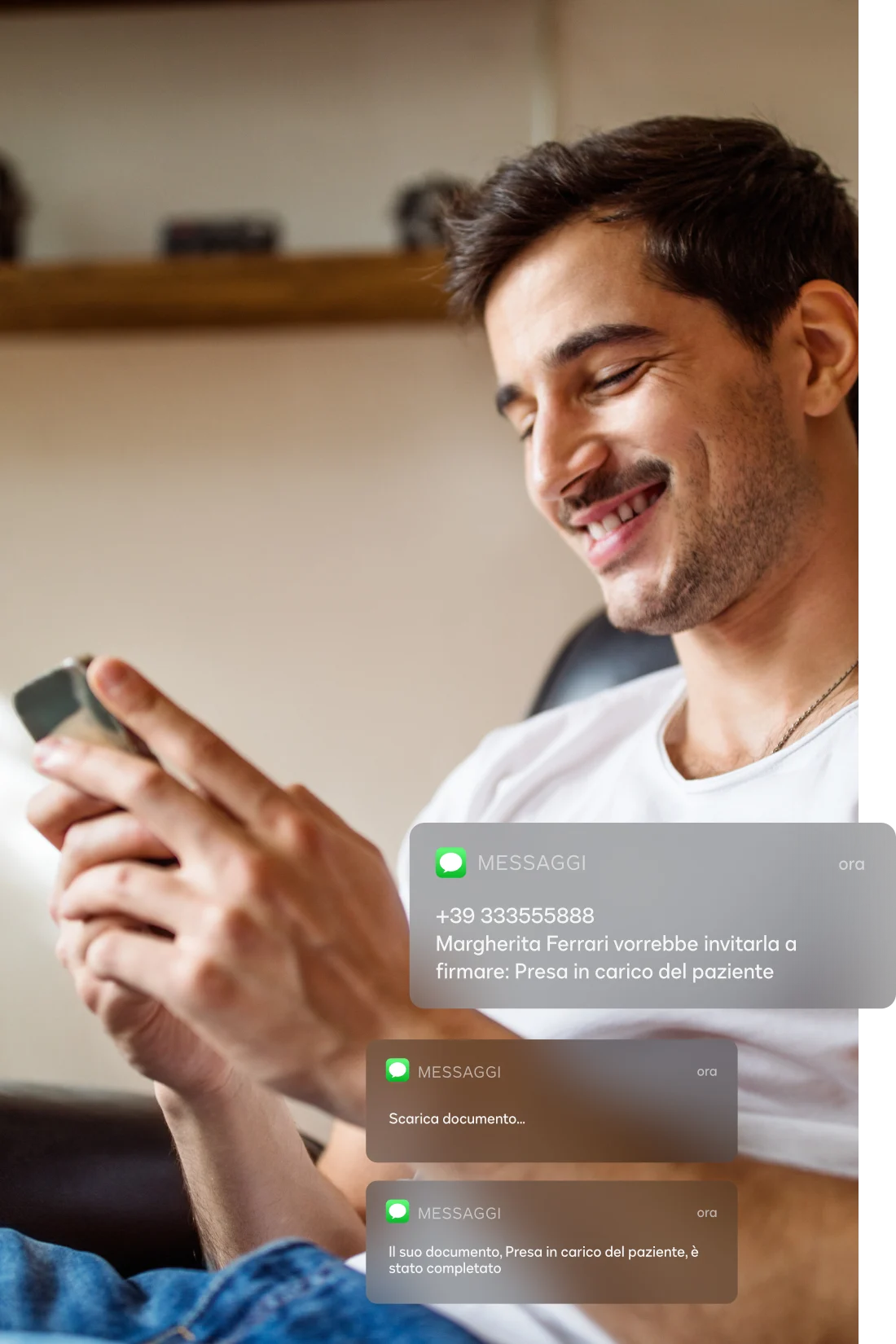 Uomo sorridente seduto che usa il suo cellulare per leggere le notifiche di DocuSign eSignature  