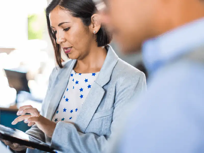 Zwei Kollegen schauen auf den Tablet-Bildschirm am Arbeitsplatz