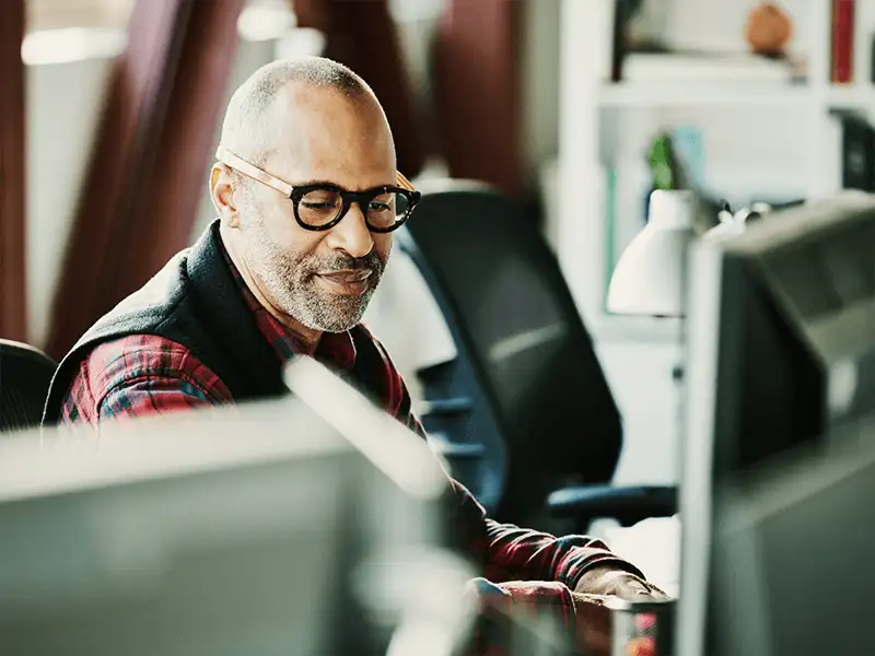 Ein Mann mit Brille, der sitzt und arbeitet