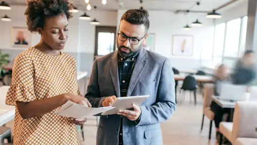 Two businesspeople reviewing documents together in an office